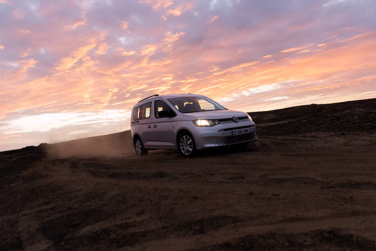 Volkswagen Caddy en un paisaje con cielo nublado al atardecer