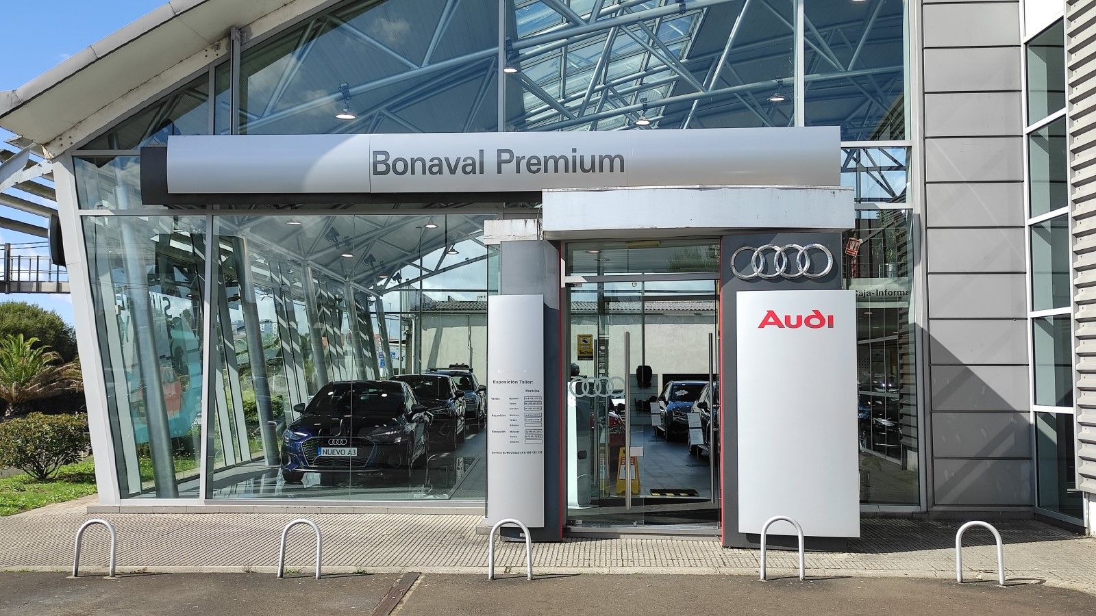 Fachada de una concesionaria Bonaval Premium de Audi, mostrando un vehículo de la marca Audi en exhibición a través de los grandes ventanales de vidrio.