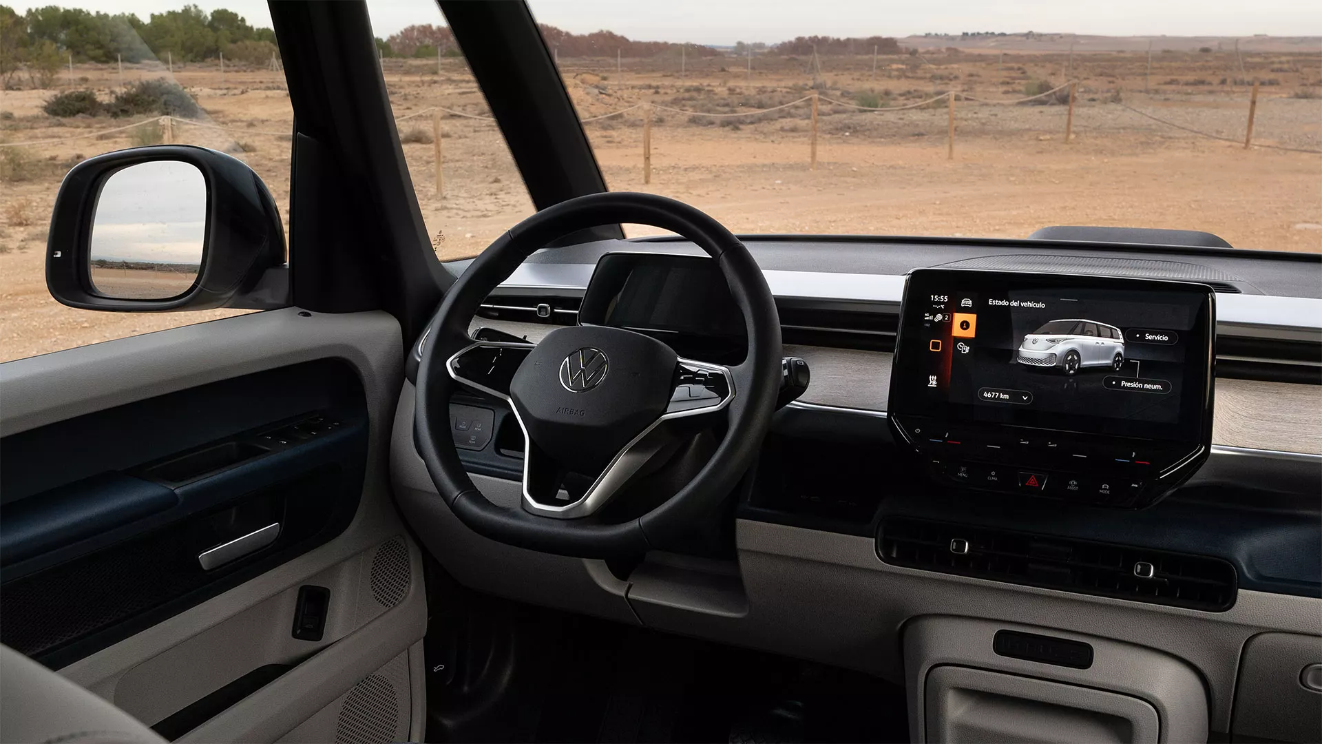 Interior del Volkswagen ID Buzz Cargocon pantalla digital, volante y espejos retrovisores visibles en una escena de campo