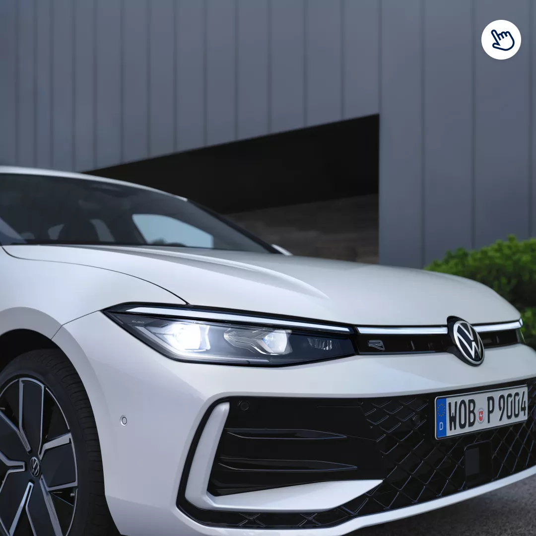 Vehículo Volkswagen Passat de color blanco con luces LED y parrilla frontal distintiva, estacionado frente a una pared gris.