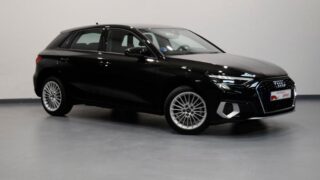 Audi A3 Sportback negro estacionado en interior iluminado