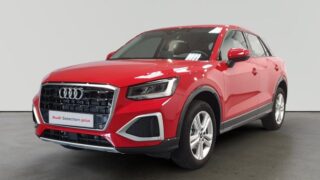 Audi Q3 rojo en exhibición con emblema Audi Selection plus