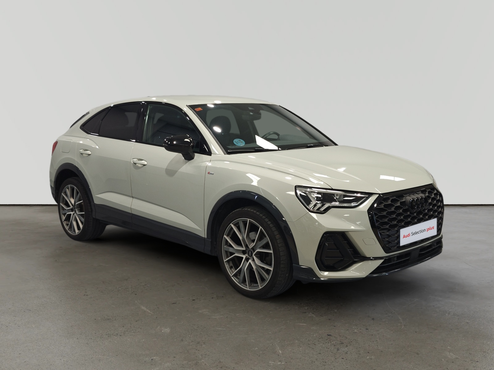 Audi Q3 blanco estacionado en interior iluminado