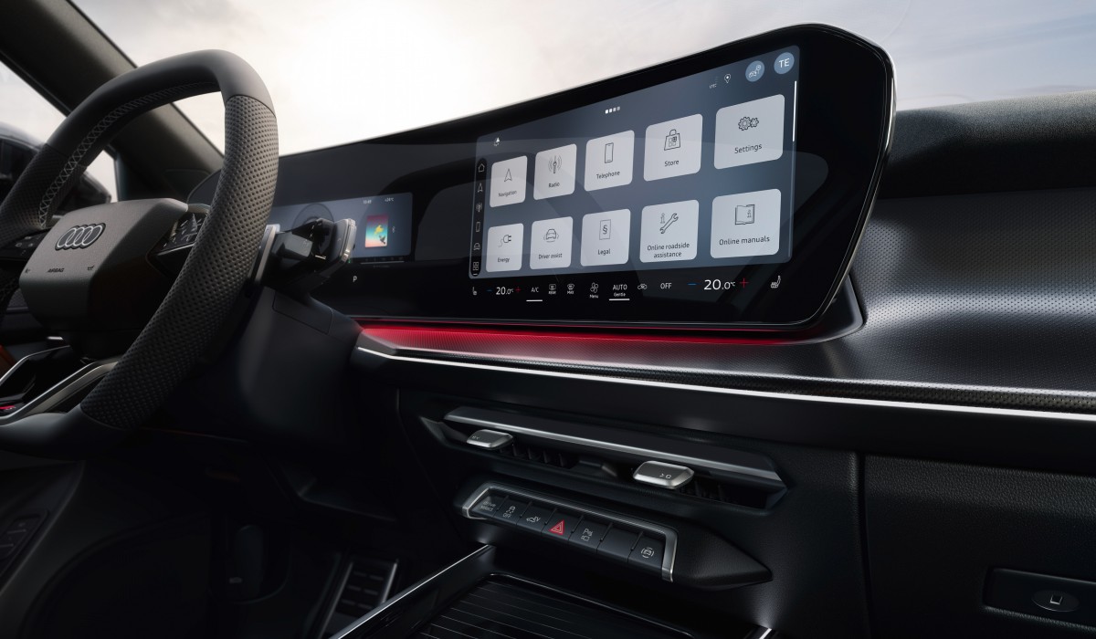 Consola central de un Audi con pantalla táctil mostrando menús de aplicaciones y climatización.