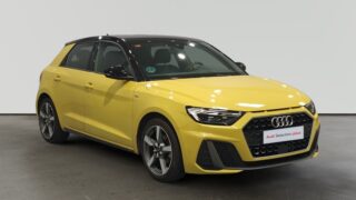 Audi compacto amarillo con detalles negros en exhibición interior