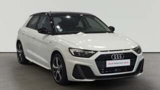 Audi blanco con detalles negros en exhibición en sala cerrada