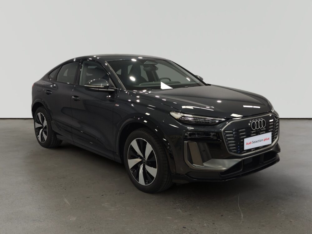 Audi negro estacionado en interior con diseño moderno y luces delanteras delgadas
