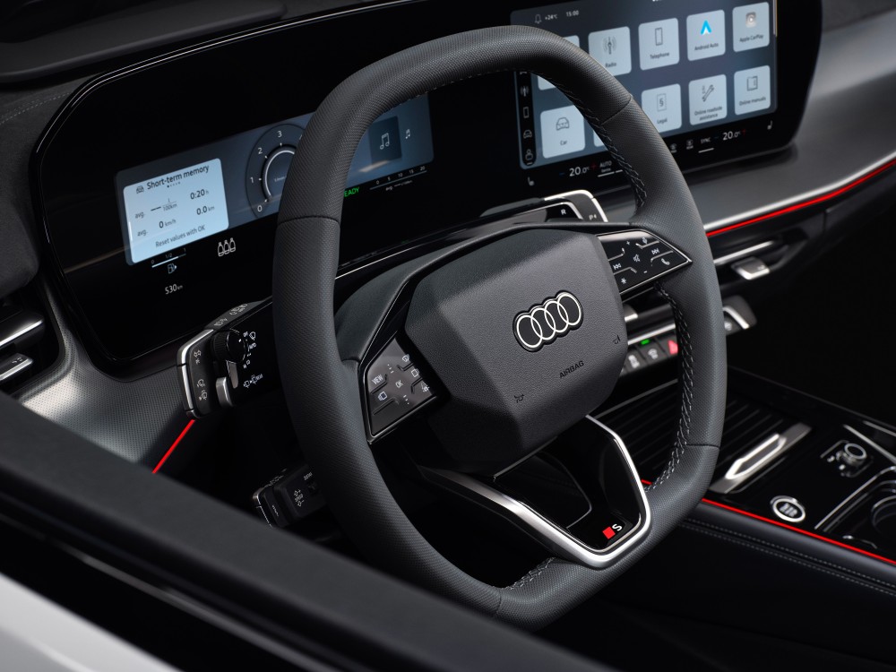 Interior de Audi Q3 con volante multifunción y pantalla digital de infoentretenimiento.