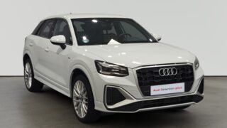 Audi Q3 blanco estacionado en interior con letrero Audi Selection plus