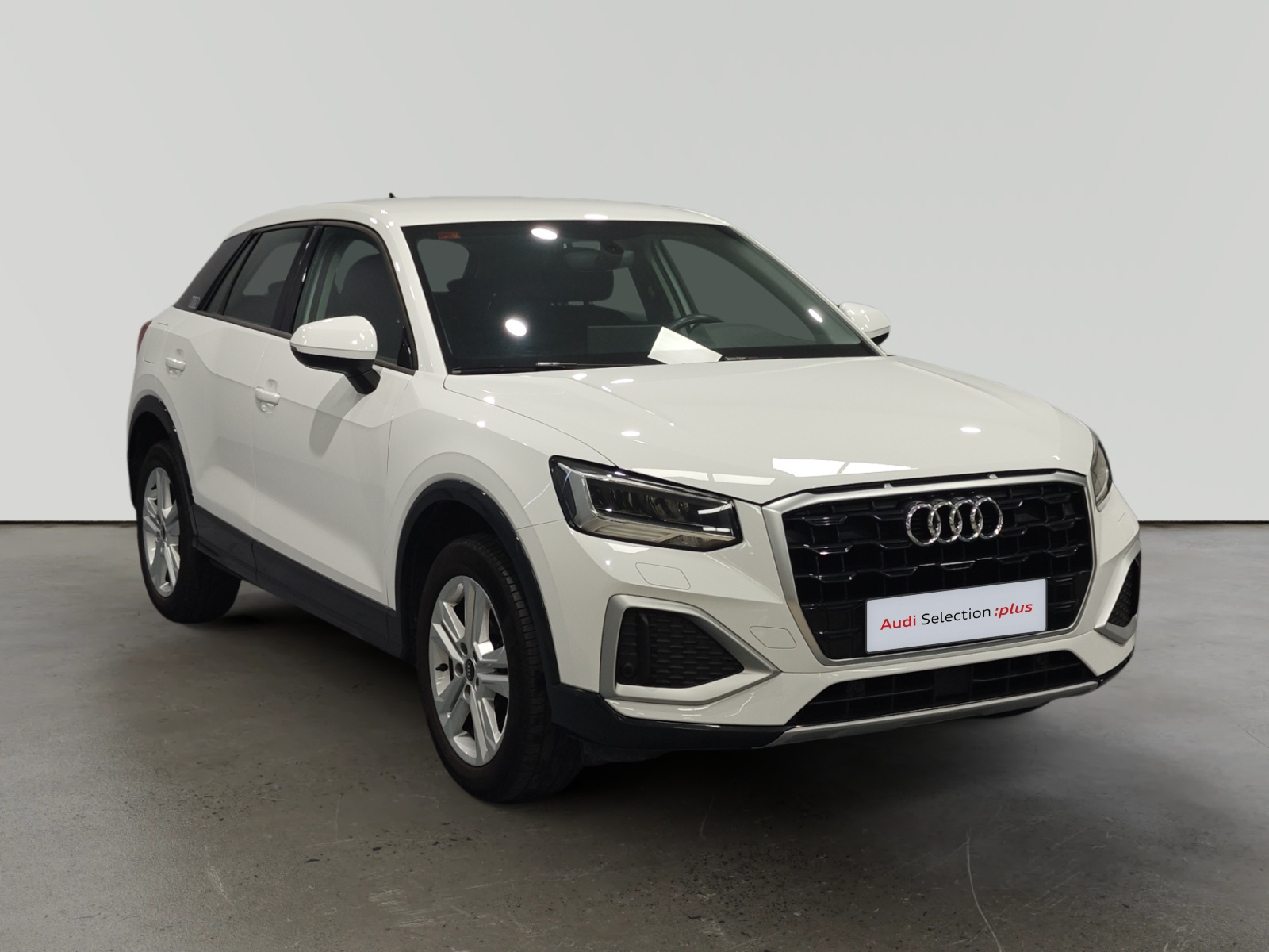 Audi Q3 blanco estacionado en interior con letrero Audi Selection plus