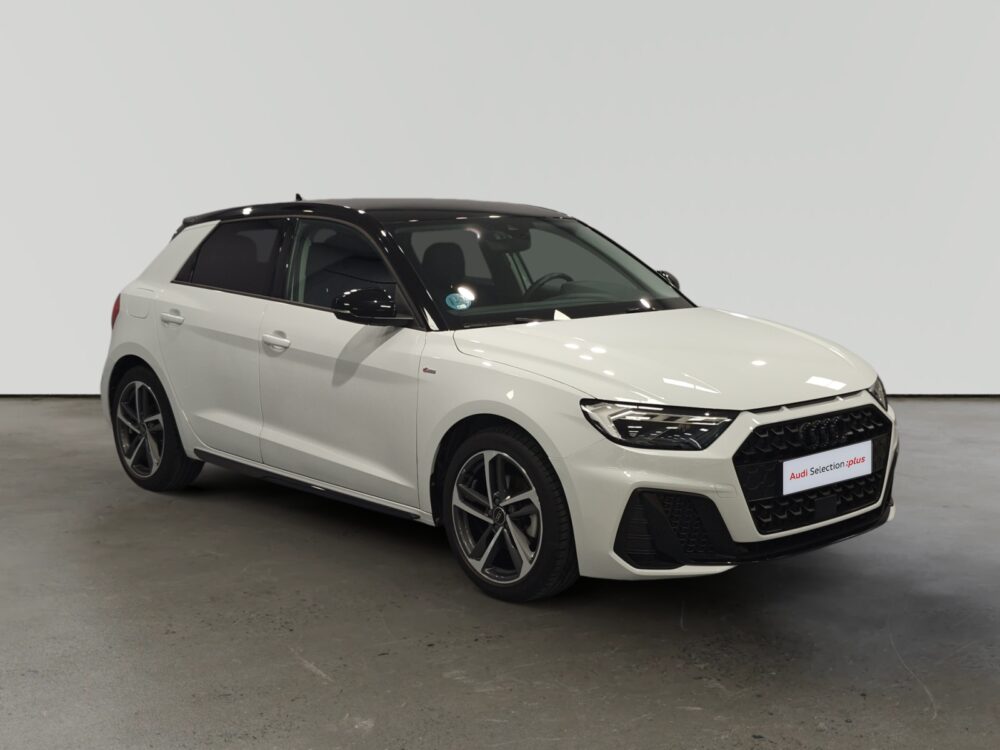 Audi compacto blanco estacionado en interior iluminado