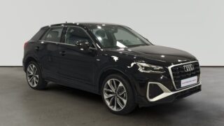 SUV Audi Q3 negro estacionado en interior iluminado