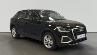 Audi Q3 negro estacionado en interior iluminado