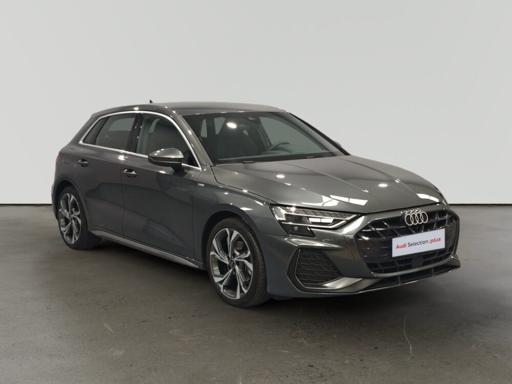 Audi compacto oscuro estacionado en un espacio cerrado con iluminación artificial