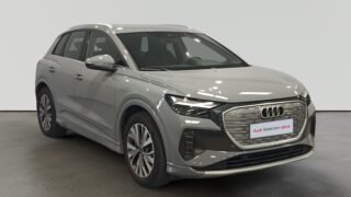 Audi Q3 plateado estacionado en interior con letrero Audi Selection plus
