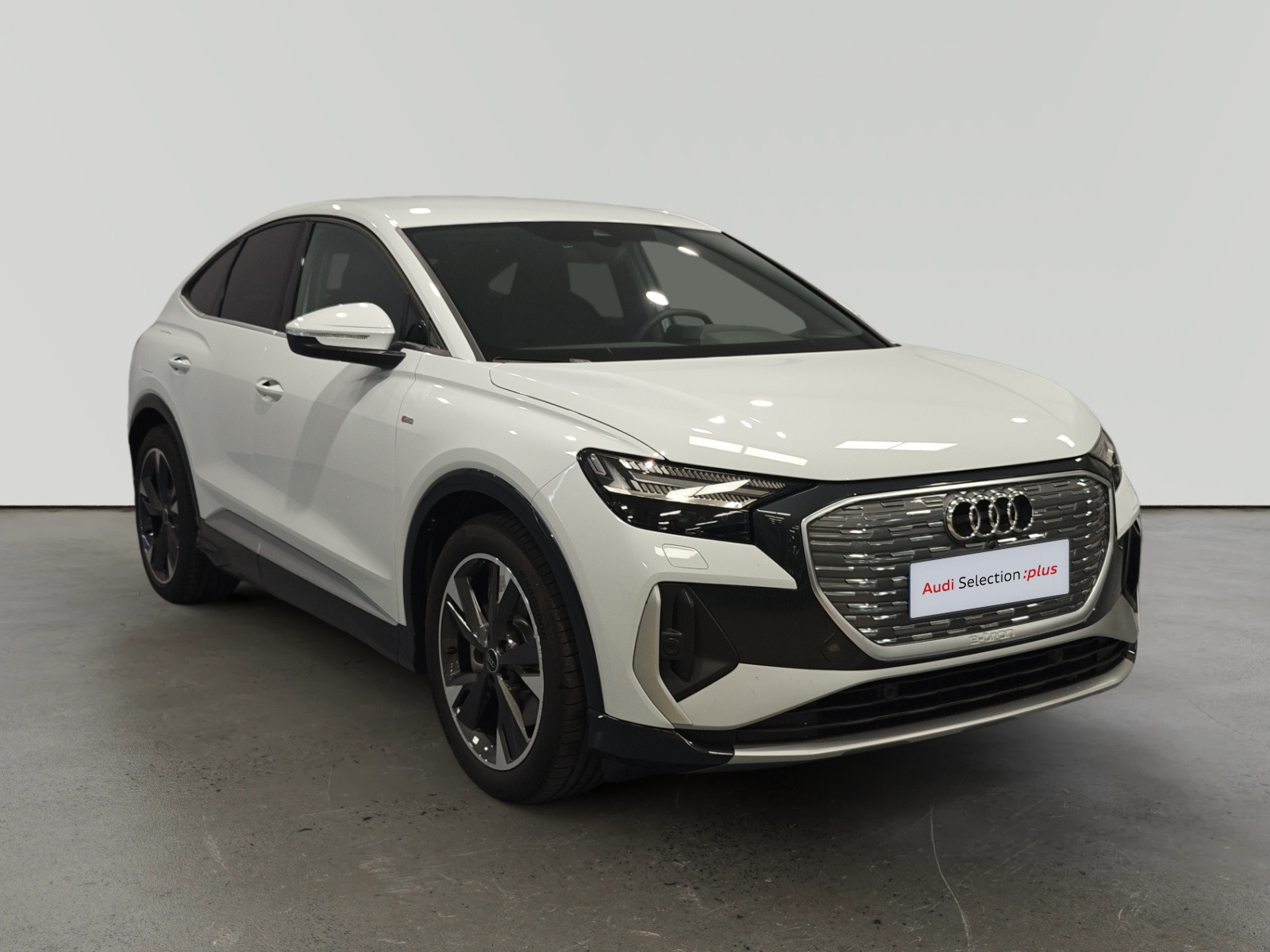 Audi Q3 blanco estacionado en interior con letrero Audi Selection plus