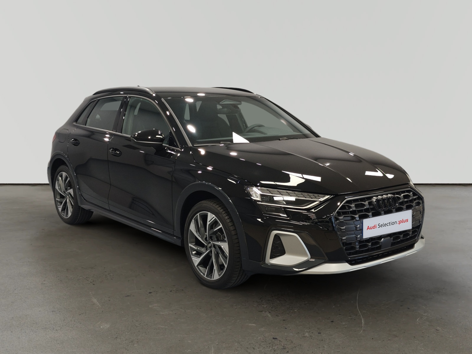 Audi Q3 negro estacionado en interior con letrero Audi Selection plus