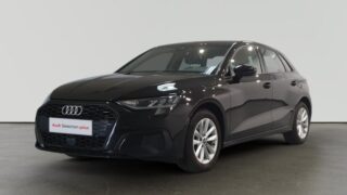 Audi negro estacionado en interior con letrero Audi Selection plus