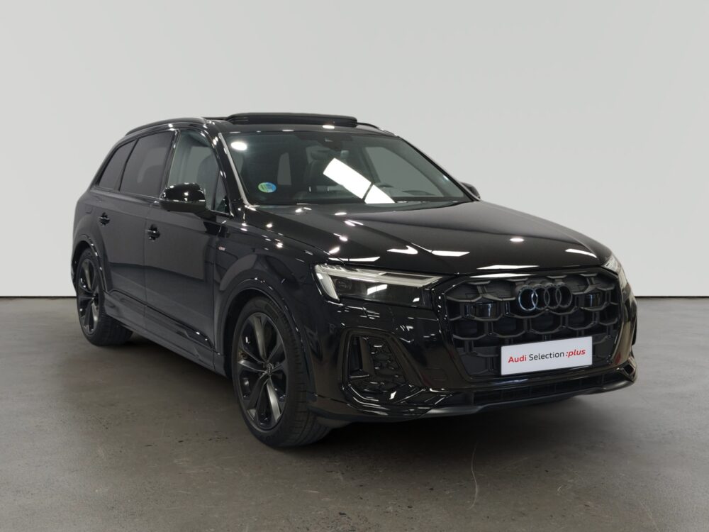 Audi Q5 negro estacionado en interior con letrero Audi Selection plus