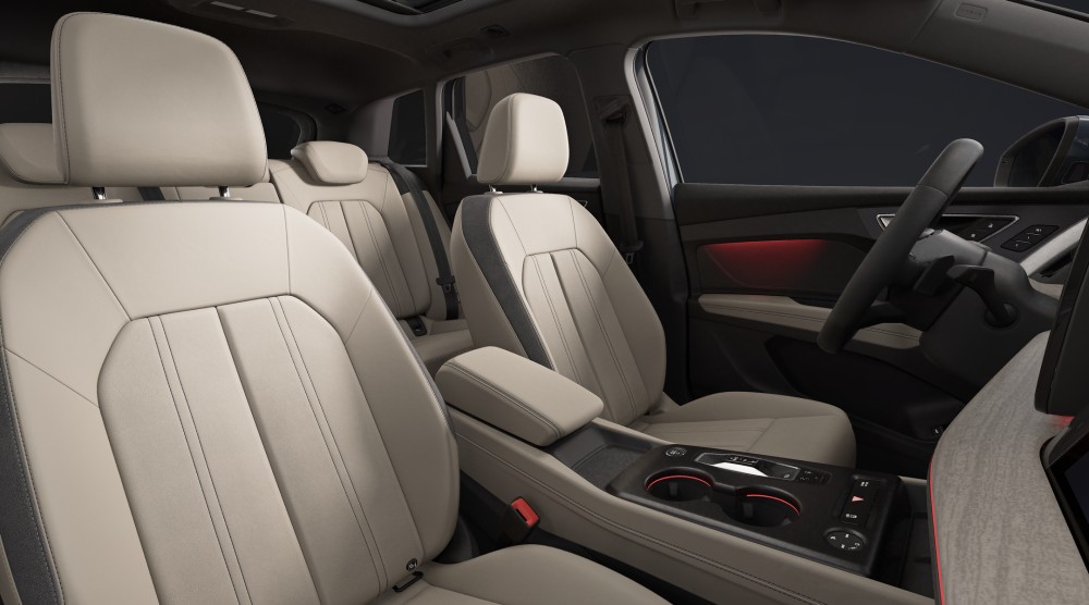 Interior de Audi Q4 etron con asientos de cuero beige y volante negro