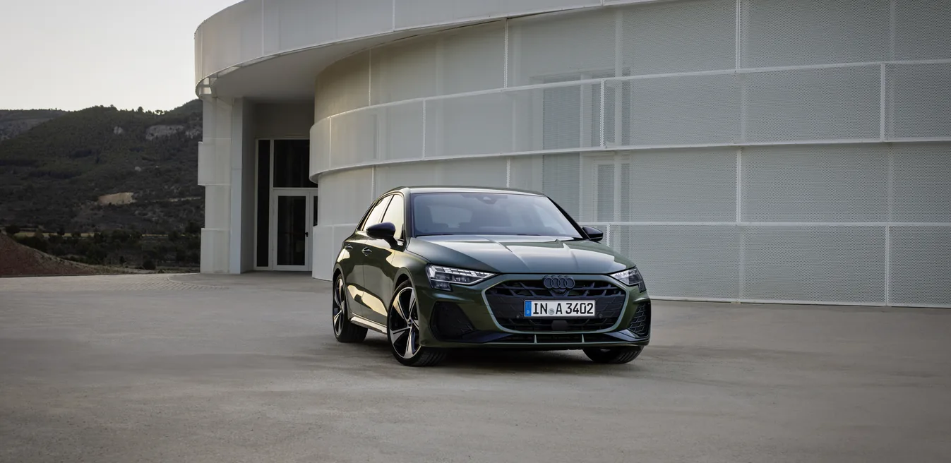 Audi A3 eléctrico negro estacionado frente a edificio moderno