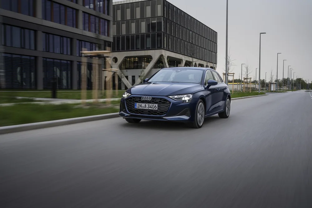 Audi A3 e-tron azul en carretera urbana moderna