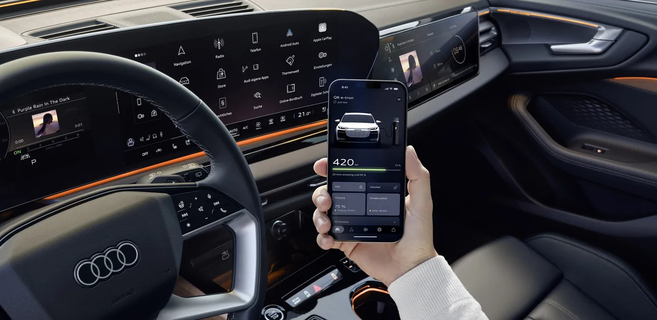 Audi Q6 e-tron con app My Audi mostrando autonomía de 420 km en el smartphone