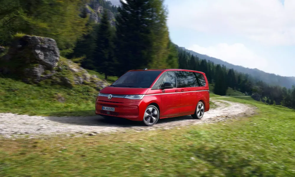 Volkswagen multivan rojo en camino de montaña