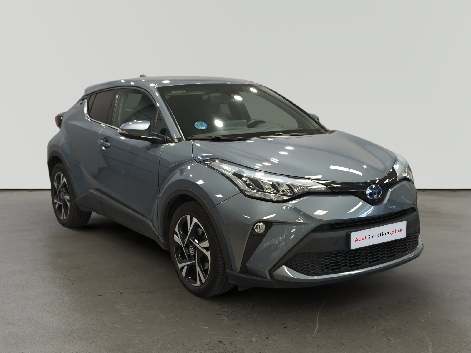 Toyota C-HR híbrido gris en sala de exposición