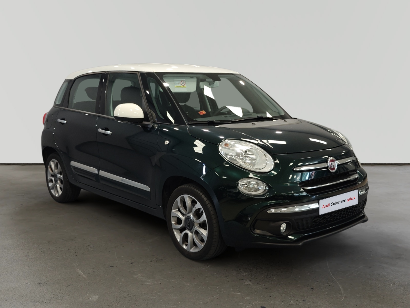 Fiat 500L negro con interior beige en sala de exposición