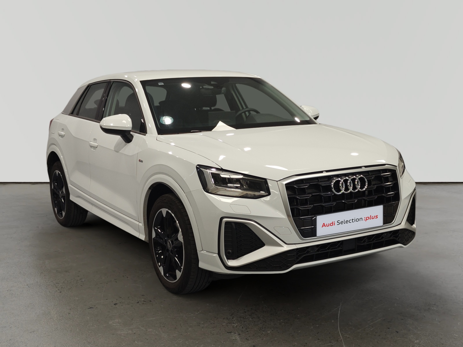 Audi Q2 blanco aparcado en estudio con fondo gris