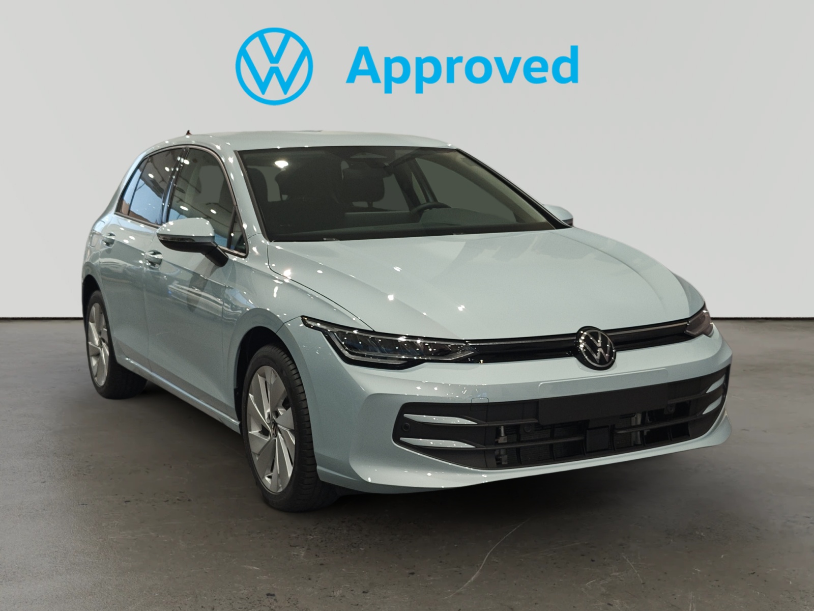 Volkswagen Golf blanco aparcado con logo Approved de Volkswagen al fondo
