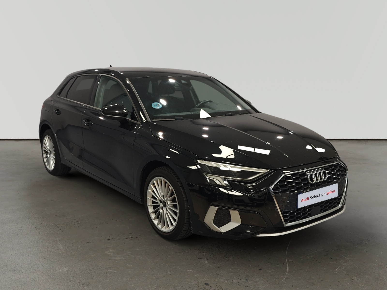 Audi A3 Sportback negro con llantas plateadas en estudio
