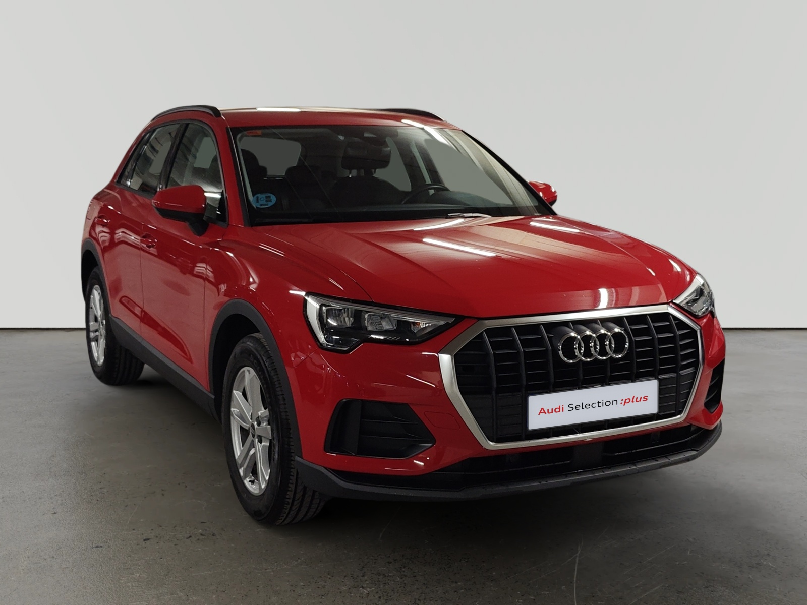 Audi Q3 rojo estacionado en showroom visto desde el frente