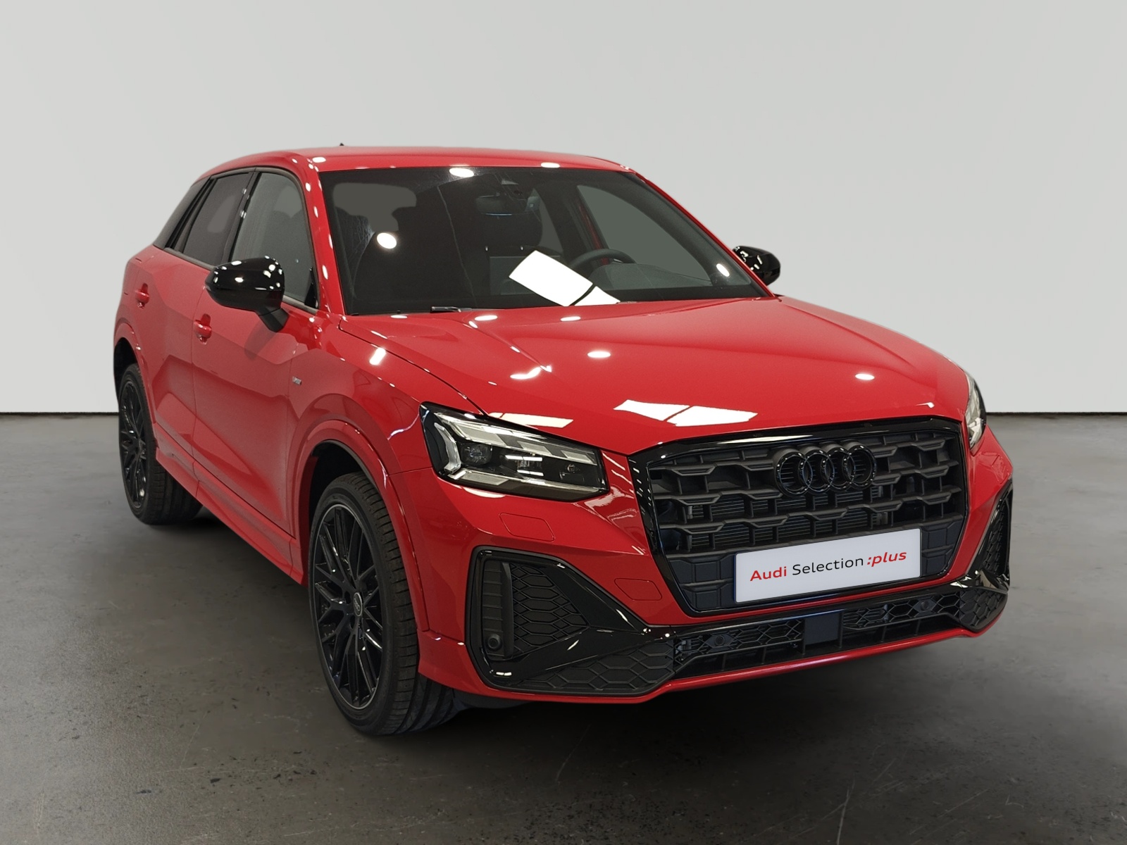 Audi Q2 rojo en sala de exposición con placa de selección oficial