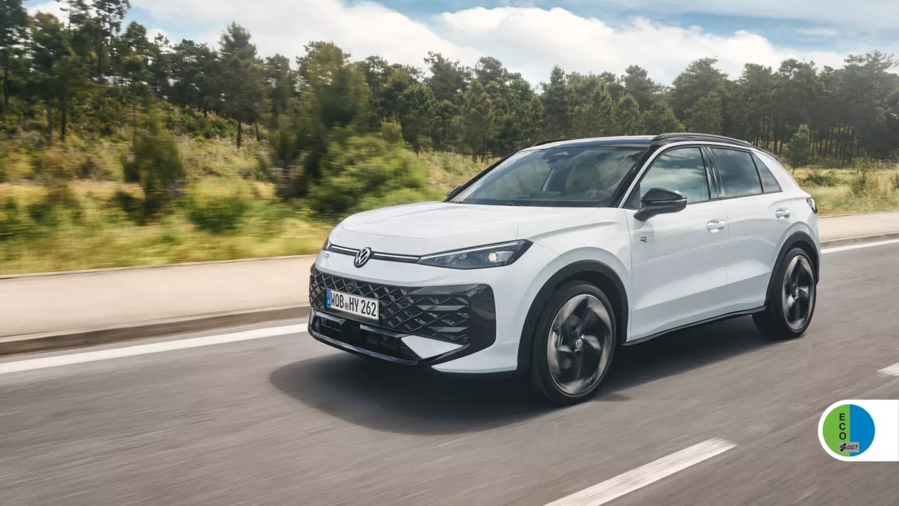 Volkswagen T-Roc híbrido blanco circulando por carretera con bosque al fondo